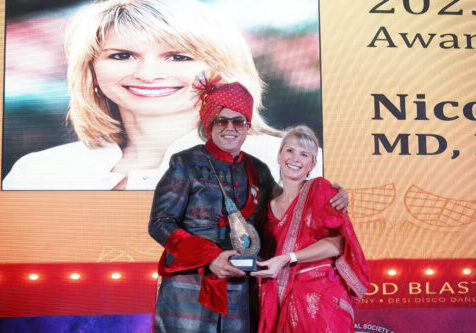 Dr. Nicole Rogers accepting the Golden Follicle Award from Dr. Kapil Dua